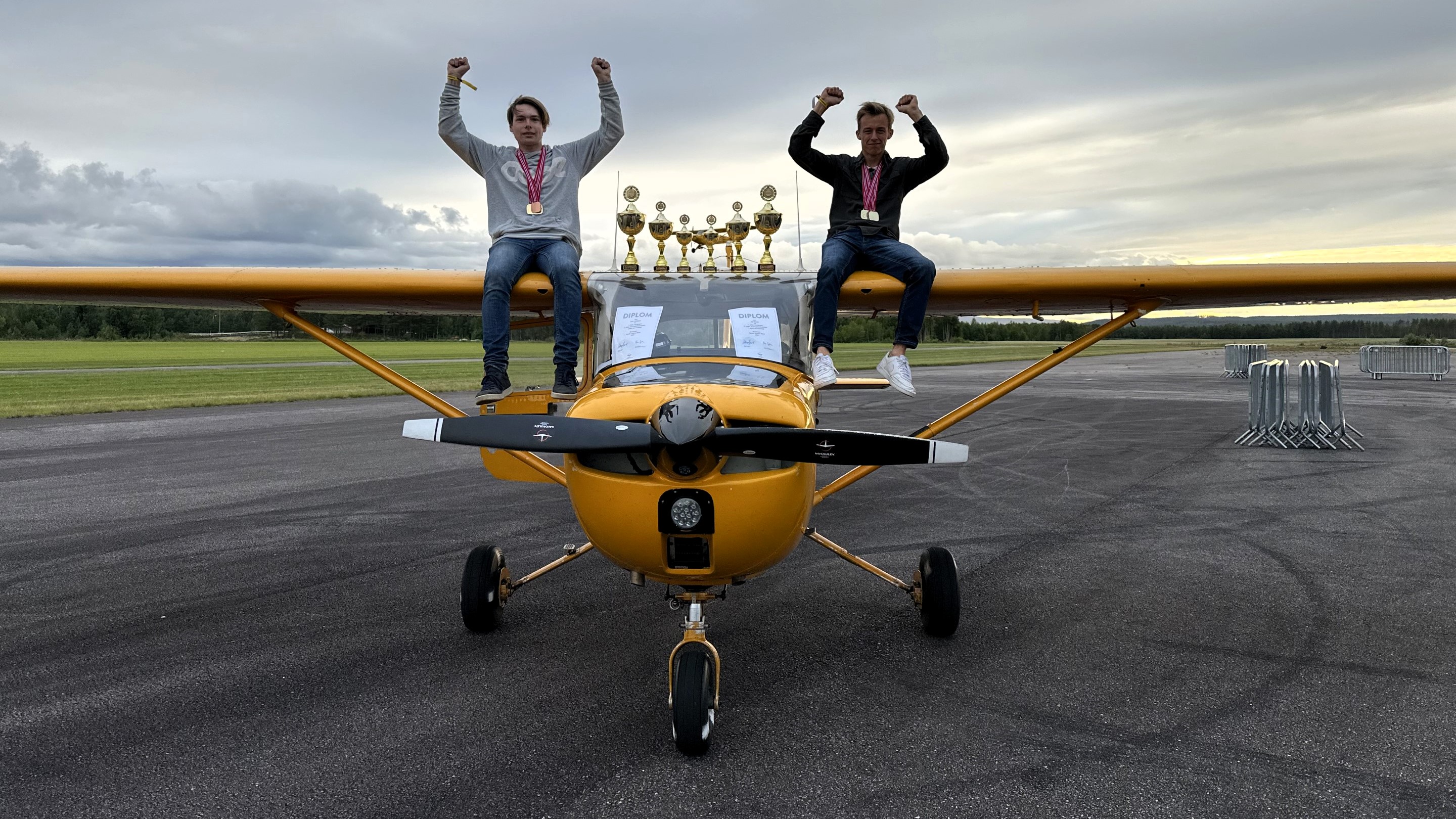 Nordiske mestere i presisjon, pilot Jip Verwer (t.h.) og navigatør Felix Joelsson (t.v.) (bak pokalene ser vi Odin Dale som flyr solo - landingsrunder i imponerende to og en halv time!)